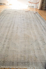 Ivory fringe and distressed texture of the vintage Oushak carpet's end.