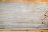 Distressed texture and subtle charcoal patterns on a vintage Oushak rug's ivory pile.