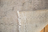Distressed Oushak carpet reverse with processing numbers, secured edge, and subtle floral pile.