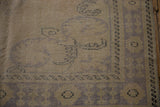 Textured corner of a Vintage Oushak rug, showing distressed beige pile and faded pale blue patterns.