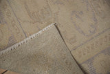 Distressed vintage Oushak rug pile, showing even wear, woven foundation, and ivory fringe.