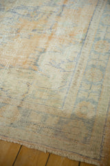 Distressed corner of vintage Oushak carpet, highlighting textured weave and faded royal blue and ivory tones.