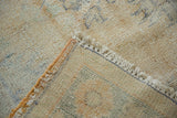 Distressed vintage Oushak rug corner, showing worn pile texture, foundation, and fringe.