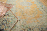 Distressed vintage Oushak carpet showing worn texture, pale orange field, and mint green floral design.