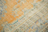 Distressed vintage Oushak rug close-up, with worn pale burnt orange field and antique ivory border.