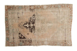 Distressed vintage Oushak rug with bold geometric medallion on a faded sand field.