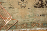 Muted dusty sand field with slate blue geometric border and original fringe.
