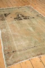 Distressed Oushak rug corner with worn short pile, original selvage, and fringe.