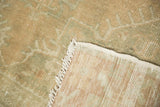 Vintage Oushak rug corner revealing distressed pile, woven foundation, and white fringe.