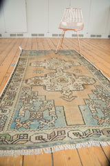 Distressed vintage Oushak rug showing low pile, geometric starburst spandrels, and sea foam abrash.