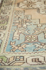 Distressed low pile on a vintage Oushak rug showing sea foam blue geometric spandrel motifs.