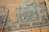 Distressed vintage Oushak rug corner, stepped geometric spandrel, patterned border, and low pile.