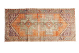 Distressed vintage Oushak rug: pale rust field, green rams horn medallions, purple spandrels. 3'11