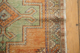 Decorative distressed Oushak rug corner featuring pale rust and oxidized green geometric motifs, original selvages.