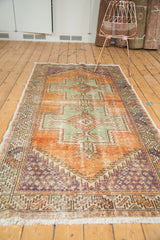 Distressed vintage Oushak rug corner: pale rust, royal blue, oxidized green geometric boteh, fringe.
