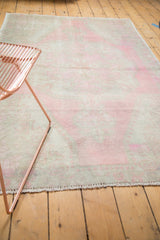Distressed low pile texture, revealing exposed knot heads in pale pink and antique ivory.