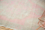 Distressed vintage Oushak rug's low pile with exposed knot heads, pale pink and antique ivory.