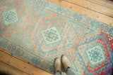 Softly distressed Oushak runner with repeating medallions in pale blush and sky blue.