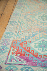 Hook and latch motifs in gem-like red, sky blue, and mint on a distressed vintage Oushak rug.