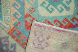 Hand-knotted foundation and distressed, colorful pile of a vintage Oushak runner.