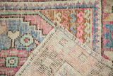 View of distressed Oushak rug corner, showing hand-knotted foundation, short pile, and original fringe.