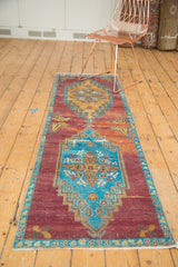 Distressed Oushak runner featuring unique blue and gold double medallions on a purple field.