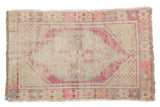 Distressed vintage Oushak rug with textured pile, showing faded plum medallion and neutral field.