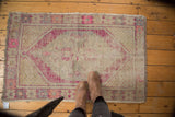 Plum purple, ivory, dusty gold on the distressed Oushak rug's lattice pattern.
