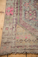 Worn pile and visible foundation on a distressed Turkish Oushak rug with bright pink details.