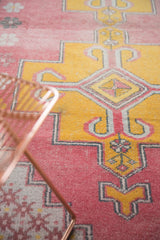 Geometric rams horn and pinwheel motifs in distressed raspberry and saffron yellow vintage Oushak.