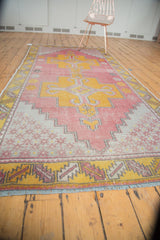 Distressed Oushak runner end, serrated leaf border in saffron, raspberry and blue fringe.