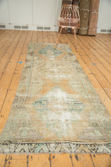 Distressed Oushak runner pile with exposed foundation, subtle beige, sand, and sky blue hues.