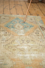 Distressed Oushak rug runner showing even short pile, faded geometric patterns, sky blue and sand tones.