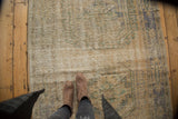 Decorative distressed Oushak rug texture showing faded ivory, denim blue, celadon green.