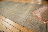 Distressed field of a vintage Oushak runner, showing faded ivory, soft blue, and green tones.