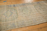 Textured detail of vintage distressed Oushak runner, showing mostly even wear and faded ivory, blue, green.