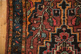 Bibikabad rug side border with dark blue field, tangerine stripes, and floral vinery.