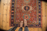 Antique Karaja rug corner: navy border, stylized rams horn motifs, cherry red field.