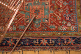 Antique Fine Karaja rug showing navy geometric border, intricate red field, and tattered end.