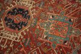 Finely woven Karaja rug's serrated motifs in cherry red, mallard green, navy, with soft pile wear.