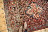 Vintage Malayer rug: Quatrefoil medallion, herati pattern, madder red, navy blue, and visible wear.