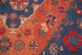 Detail of hand-woven vintage Caucasian Soumac carpet, blush red and indigo geometric pattern with a split.