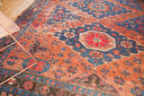 Antique Soumac carpet detail: geometric florals in madder red and indigo, showing wear.