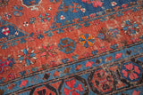 Geometric floral patterns in madder red and sky blue on a worn antique Caucasian Soumac carpet.