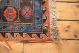 Antique Caucasian Soumac carpet corner, geometric madder red, indigo, black patterns, natural fringe.