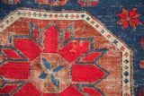 Caucasian Soumac carpet detail: geometric madder red, indigo blue patterns, with hole.