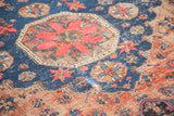Early 20th century Soumac carpet featuring geometric red medallion, indigo field, and aged texture.