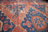 Deep blue and worn madder red Soumac rug with reciprocating geometric medallions.