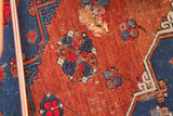 Geometric motifs and a visible hole on a madder root red antique Caucasian Soumac rug.