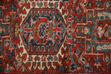 Detail of classic Heriz/Karaja geometric motifs in brick red, navy, ivory, and sky blue.